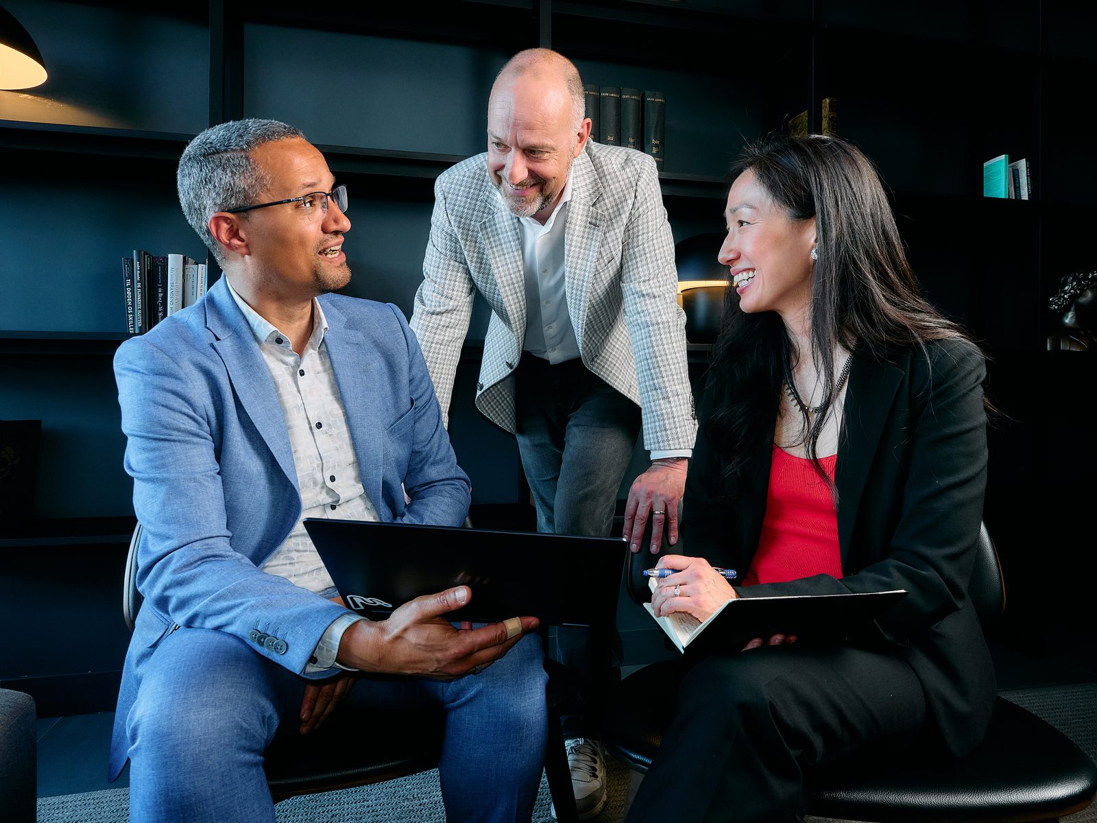 The Momenthesis team in conversation around a laptop